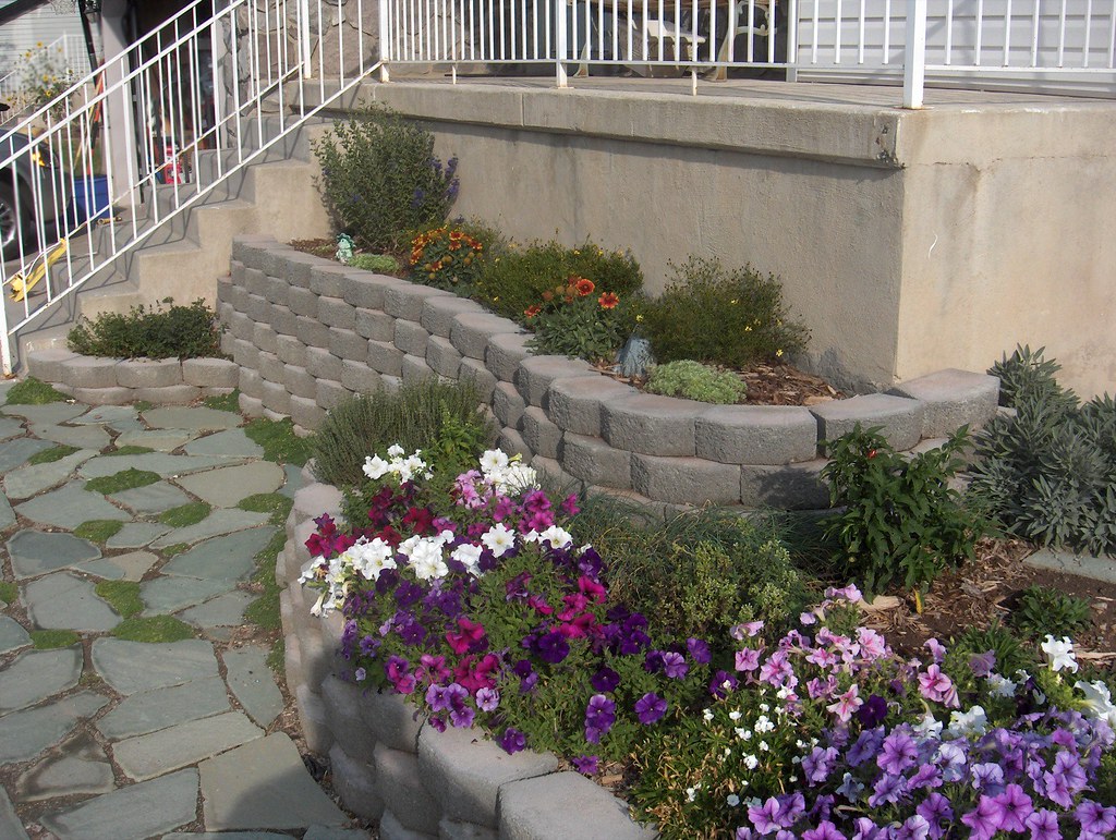 Stacked retaining wall garden bed with flowering plants