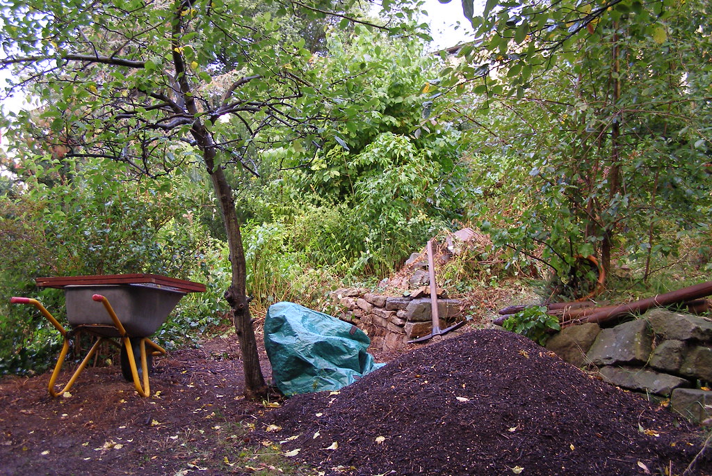 Wheelbarrow beside a fresh pile of garden mulch